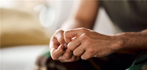 Nahaufnahme der verkrampften Hände eines Mannes.