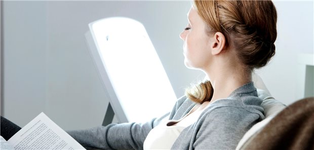 Frau macht eine Therapie mit hellem Licht um sich bei ihrer nichtsaisonaler Depressionen Linderung zu verschaffen.