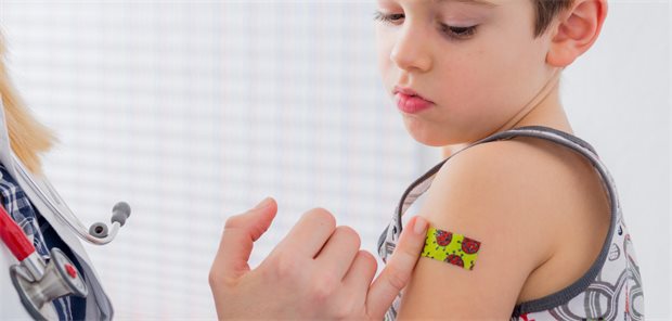 COVID-Kinderimpfstoff ist zur kommenden Saison im Regelbedarf zu beziehen Kleines Kind mit Pflaster am Oberarm (Impfstelle)
