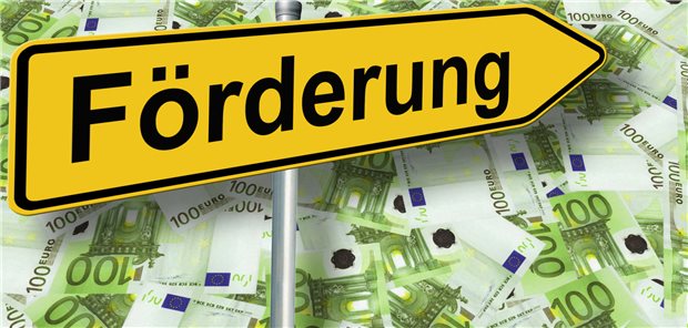 Ein Schild mit Förderung zeigt auf Geldscheine.