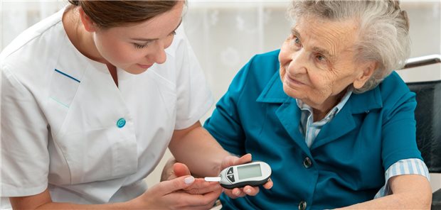 Eine Krankenschwetser misst den Blutzuckerspiegel bei einer älteren Patientin.