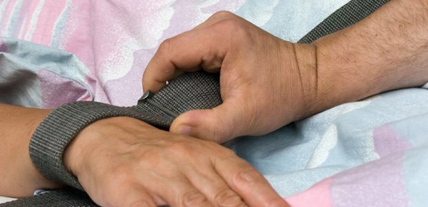 Ein Gesetz braucht Feinschliff Die Hand eines Patienten wurde mit einem Textilband fixiert.