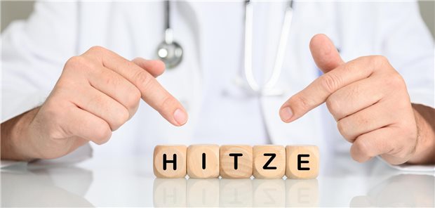 Arzt zeigt auf Würfel mit der Aufschrift "Hitze".