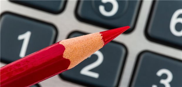 Ein roter Stift vor einem Taschenrechner.