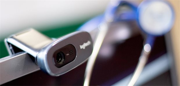 Tele-Sprechstunde wie im pädiatrischen Bereitschaftsdienst bald auch für Erwachsene in Hessen Eine Webcam und ein Stethoskop sind in einer Arztpraxis neben einem Computer bei der Videosprechstunde zu sehen.
