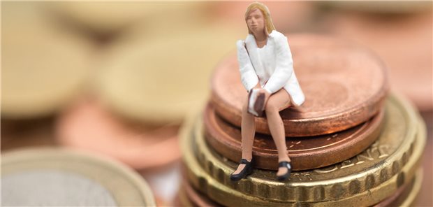 Frau sitzt auf Geldstücken.