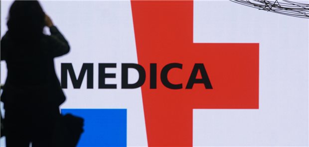 Frau vor Medica-Logo