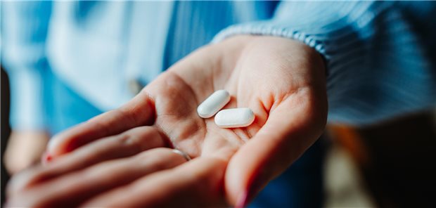 Eine Frau hält Tabletten in der Hand