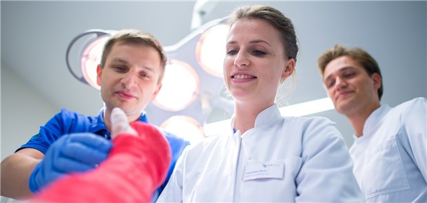 Große Umbrüche im Medizinstudium Die Medizinstudentin im PJ, Franziska Szott, legt unter Aufsicht eines Assistenzarztes einer Patientin einen Gipsverband an.