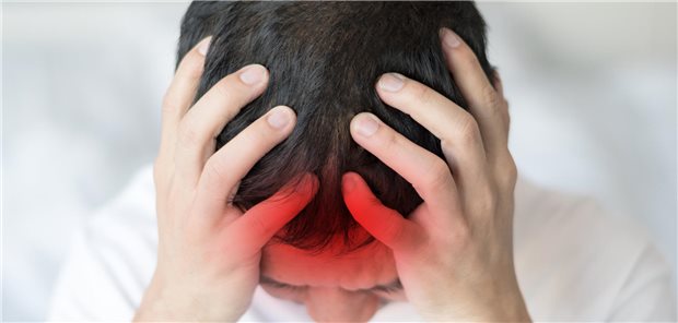 Ein Junge hält sich mit beiden Händen an den Kopf, der künstlich rot gefärbt ist.