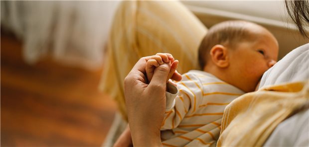 Ein Baby wird an der Brust gestillt.