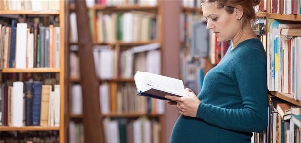 „Faktisches Berufsverbot“: Kritik an Mutterschutz reißt nicht ab Schwangere Frau liest in der Bibliothek.
