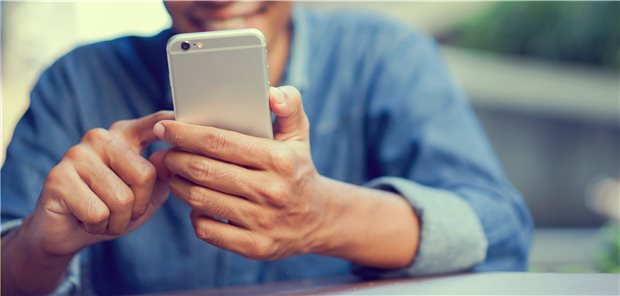 Person mit Smartphone in der Hand.