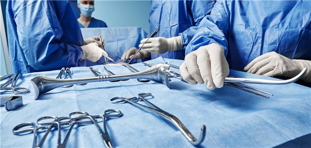 Chirurgische Krankenschwester gibt dem Chirurgen während einer Operation im Operationssaal eine chirurgische Schere.