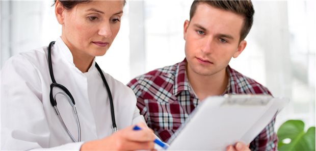 Ärztin mit jüngerem Mann, sie zeigt auf ein Blatt Papier.