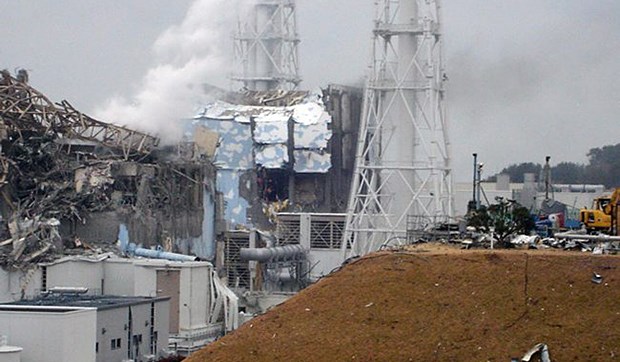 Unbewohnbare Sperrzone um die Unfallreaktoren Die Überreste von Block 4 in Fukushima, dahinter Rauch von Block 3: Größere Mengen radioaktiven Materials sind von dort entwichen.