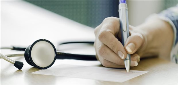 Ärztin füllt ein Rezept aus