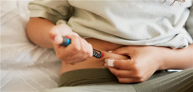 Eine junge Frau mit Diabetes spritzt sich Insulin in den Bauch.