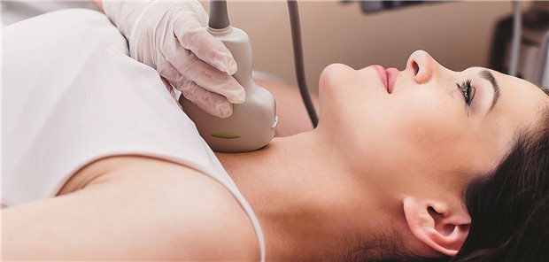 Nahaufnahme einer Ärztin, die die Schilddrüse einer Patientin mit einem Ultraschallgerät untersucht.