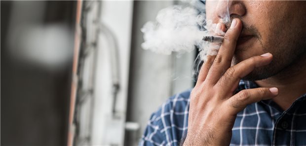 Close up young man smoking a cigarette.