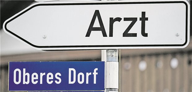 Ein Hinweisschild mit der Aufschrift "Arzt" weist den Weg zur nächsten Praxis.