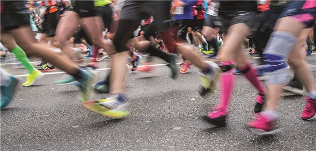 Viele Menschen joggen auf einer Straße.