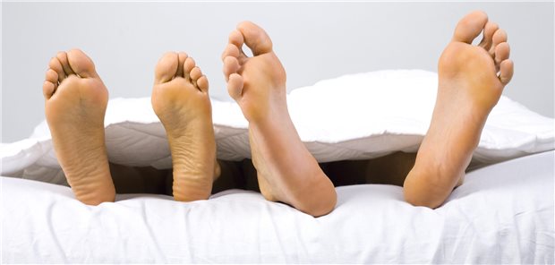 Zwei Paar Füße im Bett