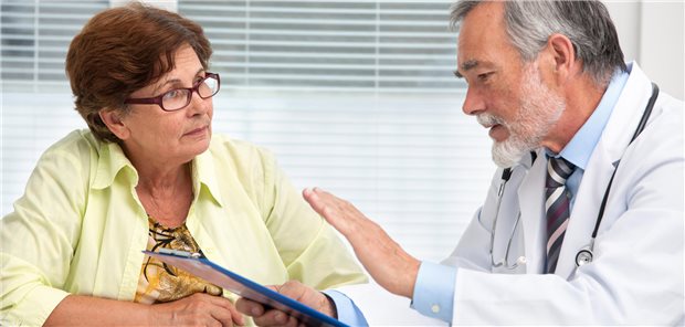 Ein Arzt spricht in seiner Praxis mit einer älteren Patientin.