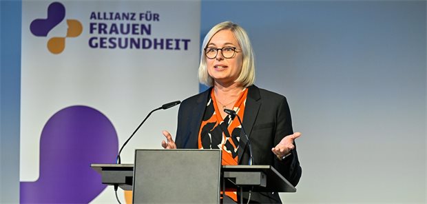 Das Bild zeigt die parlamentarische Staatssekretärin Dr. Christiane Schenderlein hinter einem Rednerpult. Im Hintergrund steht ein Banner der Allianz für Frauengesundheit. 