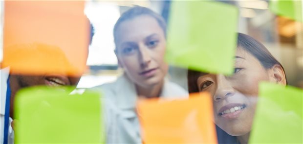 Ärzte vor Zetteln an einer Wand.