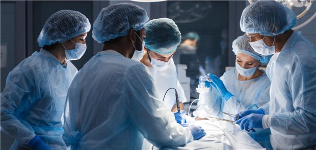 Gruppe konzentrierter Chirurgen bei der Behandlung eines männlichen Patienten im Operationssaal eines Krankenhauses.