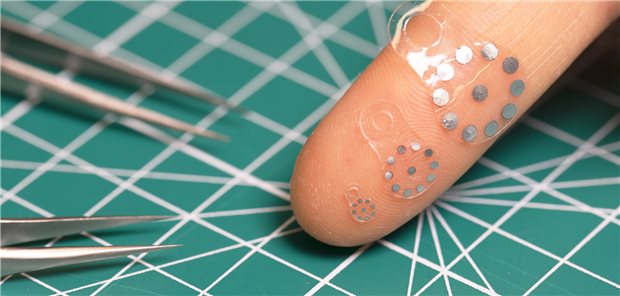 Sticker aus Hydrogel und Metall kleben auf einem Zeigefinger.