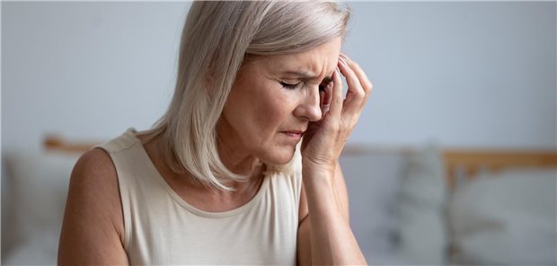 Frau fasst sich schmerzverzerrt an ein Auge