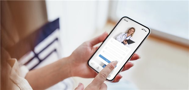 Eine Frau, die zu Hause auf ihrem Smartphone die Optionen in einer Gesundheits-App erkundet.