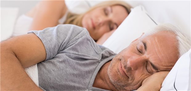 Schützt der Erholungsschlaf am Wochenende vor Demenz? Ein älterer Mann und eine ältere Frau schlafen zusammen in ihrem Bett.