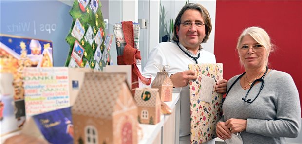 Dr. Arndt Berson und seine
Kollegin Margot Kops vor
ihrem Praxis-Gabentisch.