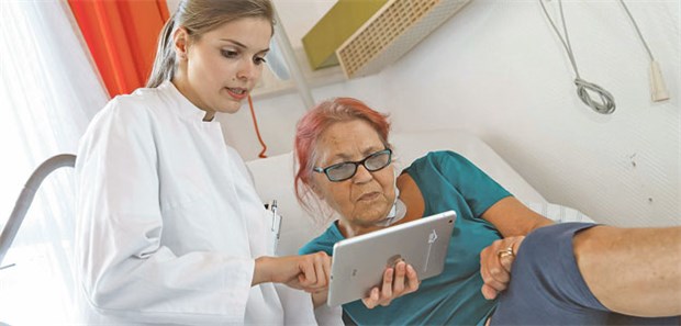 Auf Visite mit dem Tablet-PC Dr. Gesa Stöhr vom Gemeinschaftskrankenhaus Bonn erläutert einer Patientin den Krankheitsverlauf mithilfe ihrer digitalen Patientenakte.