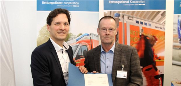 Dr. Oliver Grundei, Staatssekretär im Landesgesundheitsministerium (links), mit dem stellvertretenden RKiSH-Geschäftsführer Jan Osnabrügge bei der Übergabe der Genehmigung für den AEF-Einsatz.