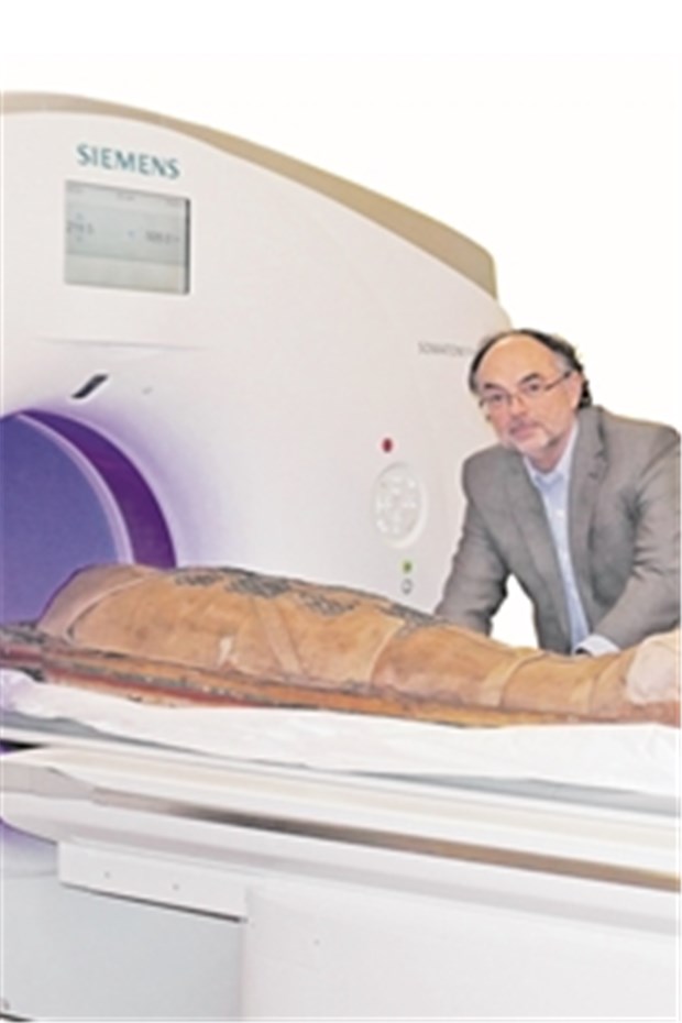 Mumien in neuem Licht Dr. Roman Sokiranski mit Mumie am Computertomographen.