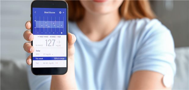 Frau hält Smartphone mit App hoch.