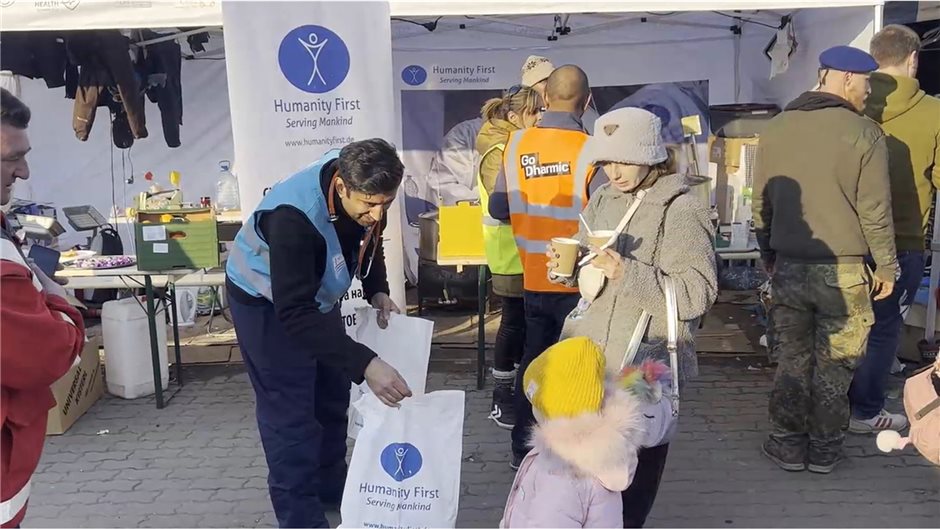 Dr. Wjahat Waraich verteilt Hilfsgüter an Ankommende.