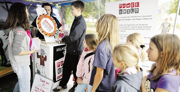 Drehen am Quiz-Rad - Kinder bei einer Info-Aktion von Power-Child.