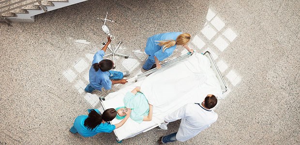 Ostergeschenk für die Kliniken Drei Schwestern und ein Arzt verlegen einen Patienten in einem Krankenhaus.