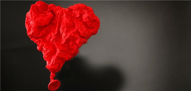 Ein verschrumpelter roter Luftballon mit ganz wenig Luft.