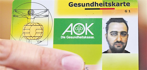 Künftig attraktiv für Kassen? Ein Flüchtling aus Syrien hält seine Gesundheitskarte empor.