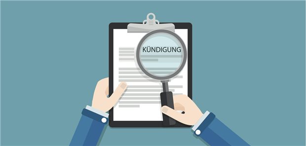 Lupe zeigt das Wort "Kündigung" auf einem Blatt Papier.
