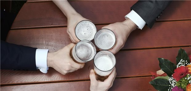 So viele alkoholbedingte Krankheitstage wie nie zuvor Vier Personen im Anzug stoßen mit einem Glas Bier an.