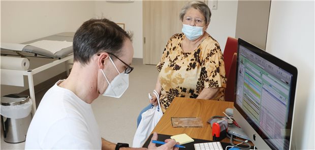 Jeder fünfte Corona-Piks erfolgte in einer Praxis Ein Hausarzt in Thüringen bespricht mit einer Patientin die Corona-Impfung.