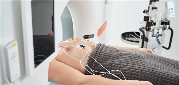 Person liegt in einem CT-Gerät und hat Elektroden auf der Brust kleben. 