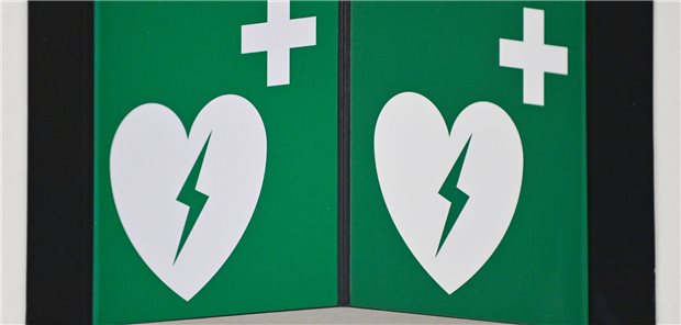 Ein Hinweisschild auf einen Defibrillator hängt an einer Wand. Ein elektronisches Herzinfarktregister soll helfen, die Herzgesundheit und die Versorgung der Patienten in Sachsen-Anhalt zu verbessern.